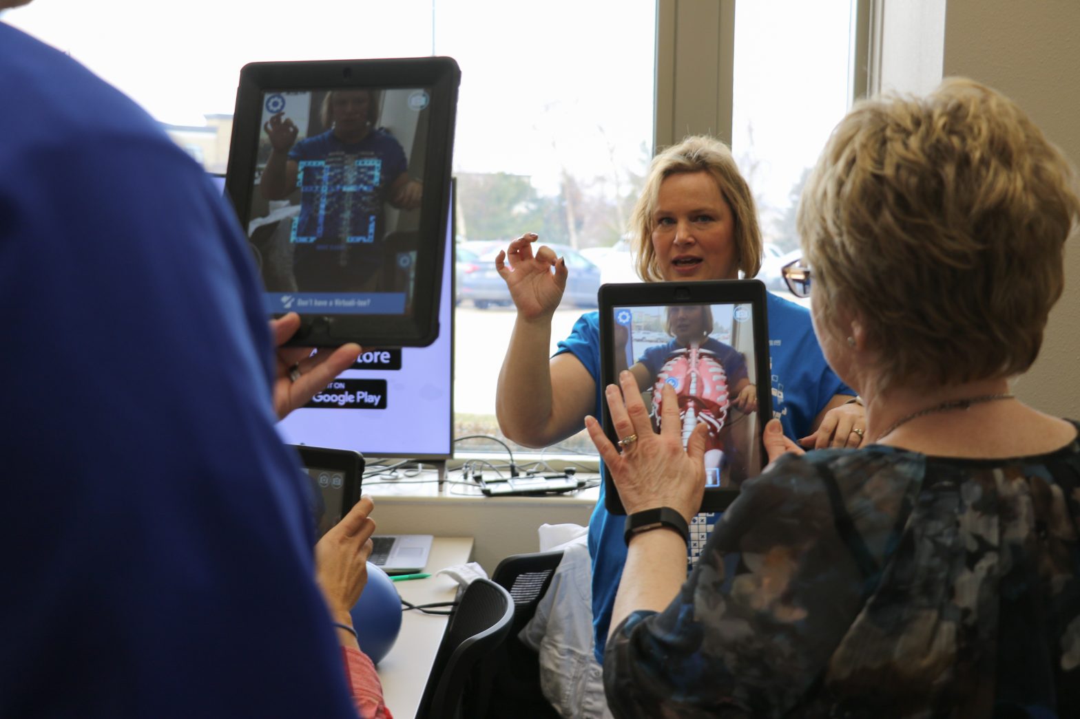 An AR educator teaching CRAEA staff virtual anatomy using a special program on an iPad.