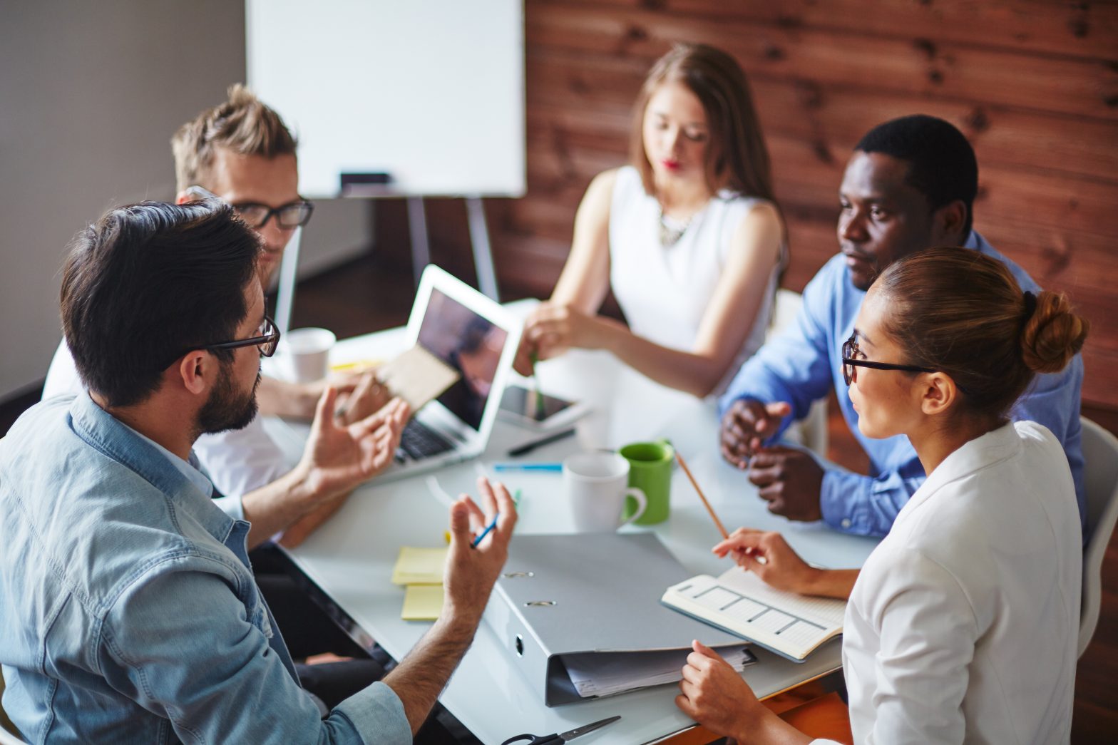 A small group of adults meeting together and discussing trainings.