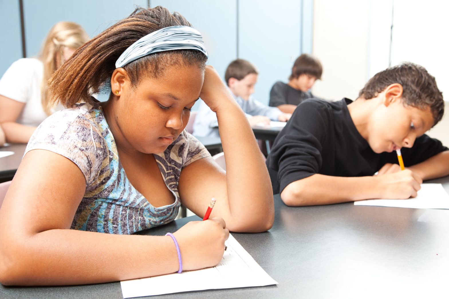 Classroom of diverse students taking testing in school.
