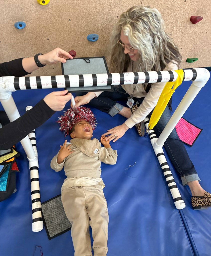 Dr. Elizabeth Voigt, Occupational Therapist with Central Rivers AEA, joins a Lincoln Elementary student as they explore and learn through play in a new accessible gym.