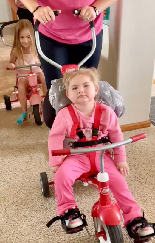 Kori riding bikes with her sister.