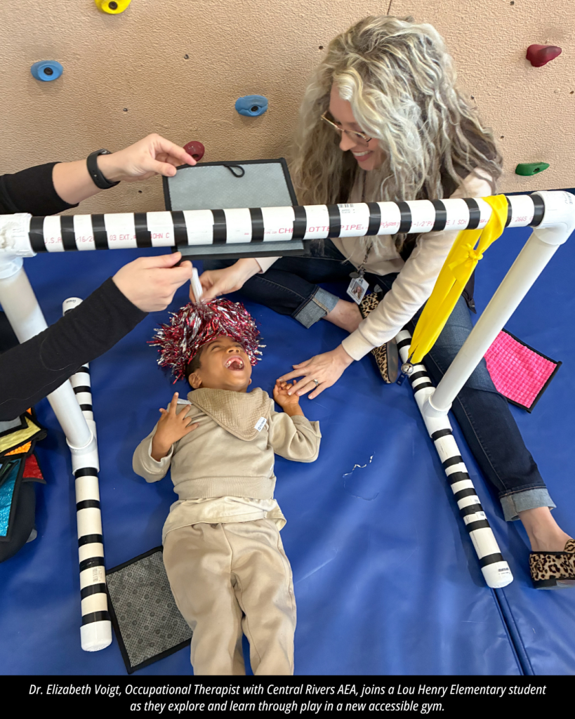 Dr. Elizabeth Voigt, Occupational Therapist with Central Rivers AEA, joins a Lou Henry Elementary student as they explore and learn through play in a new accessible gym.