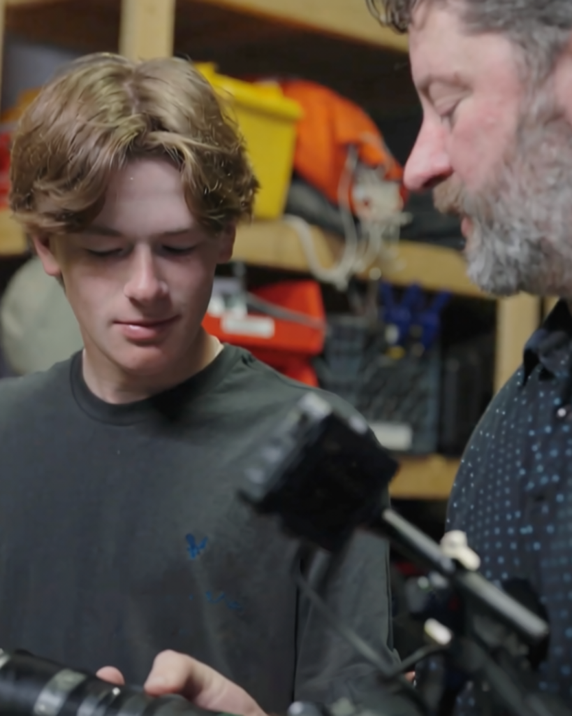 Student Grady learning about video equipment with Brian at Amperage.